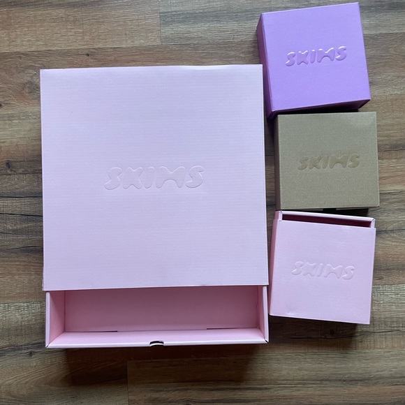 Skims blush pink rigid boxes with tone-on-tone debossed wordmark across multiple sizes