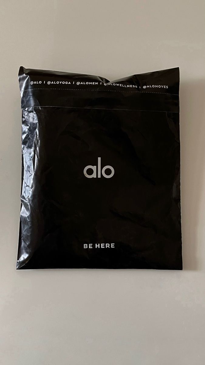 Alo Yoga matte black custom poly mailer with BE HERE messaging and social handles printed on the seam