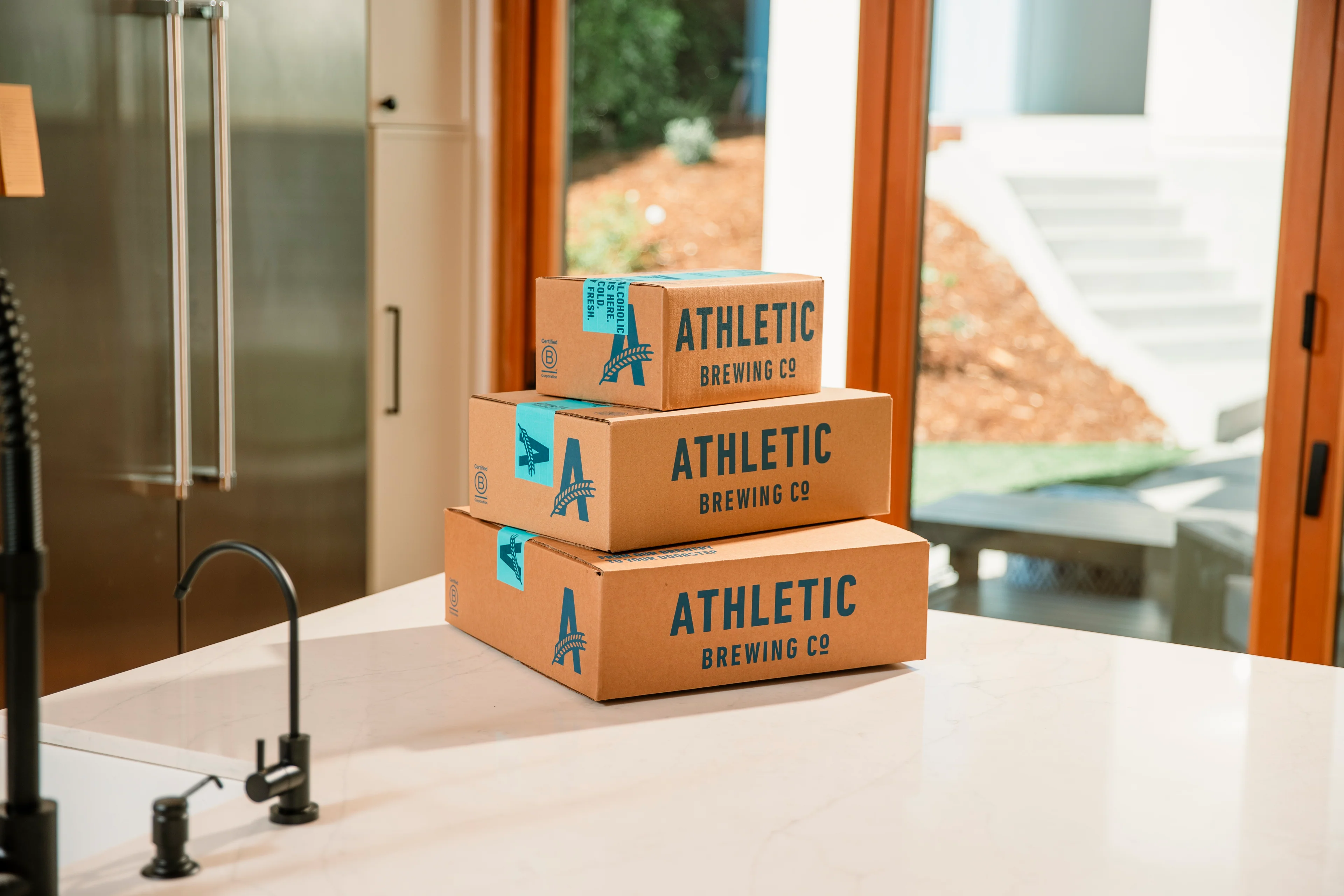 Athletic Brewing Co kraft corrugated boxes with teal custom print in three sizes for non-alcoholic craft beer
